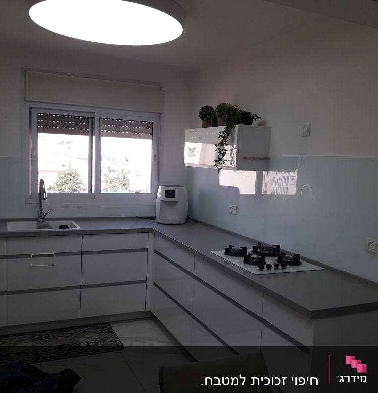 מטבח עם חלון זכוכית גדול מעל הכיור